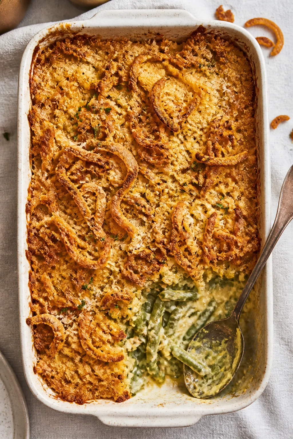 Final dish overhead: Cheesy green bean casserole just out of the oven in a 9x13 dish, edges bubbling