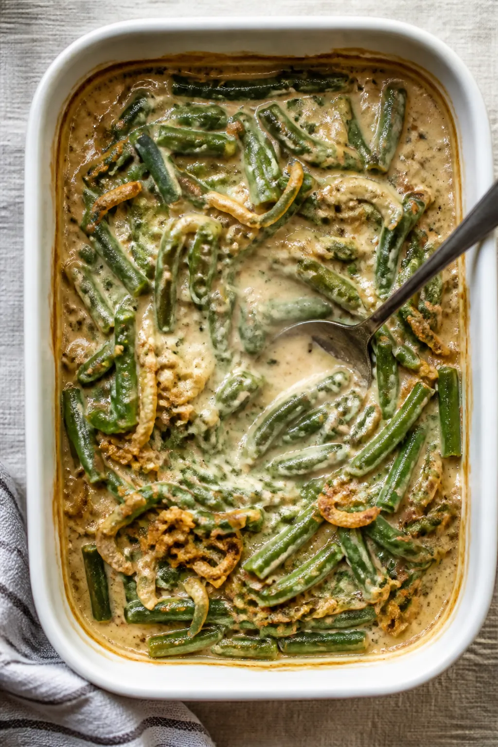 Overhead shot of the green bean casserole just out of the oven after the first bake, in a 2-quart wh